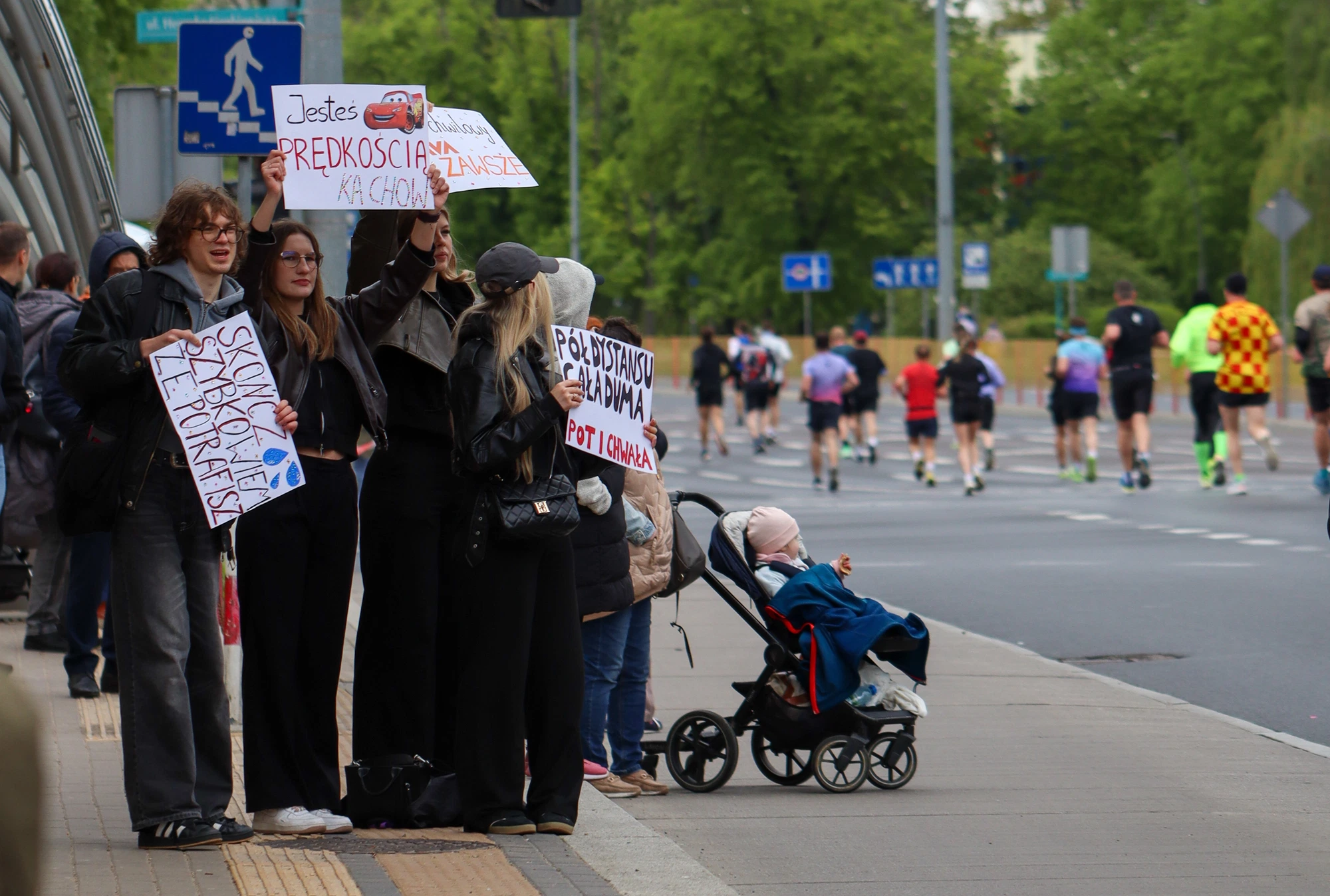 Kibice z własnoręcznie wykonanymi transparentami przy trasie półmaratonu